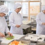 保育園の清潔な厨房で昼食を準備する調理スタッフ