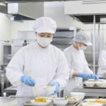 病院の厨房で患者さんの食事を準備する調理スタッフ
